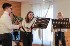 Trio klarnetowe w trakcie występu. Przed młodymi muzykami pulpity z partyturą.
