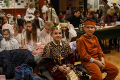 Dzieci w strojach, zasiadające na widowni. W pierwszym rzędzie chłopiec w stroju króla, a obok niego chłopiec w stroju osiołka.