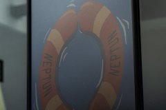 Plakat filmowy Rejs. Na kole ratunkowym napis Naptun Neptun.
