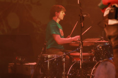 Perkusista za sprzętem. Sfotografowany z prawego profilu.