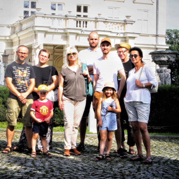 Grupa uczestników pleneru pozuje do zdjęcia przed budynkiem pałacu w Kościelcu. Razem z nimi dwoje dzieci.