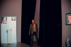 Mężczyzna w czerwonej chustce na twarzy wchodzi do wnętrza galerii Wieża Ciśnień.