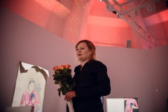 Artystka Ewa Gaj. Trzyma bukiet róż. Ubrana jest na czarno.