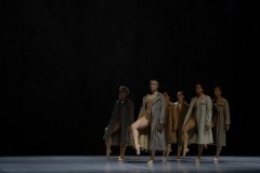 Tancerki ubrane w prochowce stoją na prawych nogach, lewe zgięte w kolanach z obciągniętymi palcami wyciągają przed siebie.
