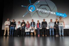 Zdjęcie grupowe na scenie jurorów, organizatorów i nagrodzonych. W tle logo FotoBitwa.