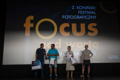 Uśmiechnięci nagrodzeni na scenie. W tle slajd 2. Koniński Festiwal Fotograficzny Focus nad Wartą.