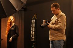 Po prawej Patryk Koszela trzymający aparat. Po lewej modelka i fragment parasola.
