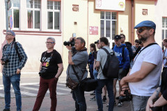 Grupa osób stoi przy budynku LOK przy ul. Urbanowskiej w Koninie. Mężczyzna w centrum kadru robi zdjęcie.