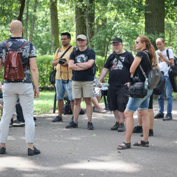 Grupa fotografów podczas rozmowy w parku.