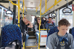 Grupa osób siedzi w autobusie.