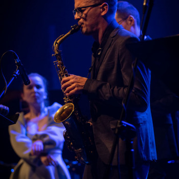 Saksofonista w planie amerykańskim. Sfotografowany w lewego profilu.