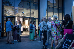 Grupy dyskusyjne przed wejściem głównym do CKiS-DK Oskard. W prawym dolnym rogu leżak z napisem: Im kultura niżasza, tym naśladownictwo bardziej rozwinięte.