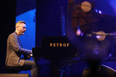 Pianista przy fortepianie Petrof.