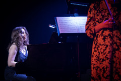 Od lewej: pianistka przy fortepianie, oświetlona partytura, fragment kobiecej sylwetki. Kobieta ubrana w  sukienkę w kwiatki.