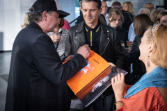 Jacek Rodziewicz rozdaje autografy. Podpisuje się na płycie winylowej z pomarańczową okładką.