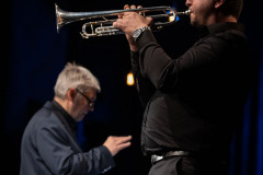 Sfotografowany z lewego profilu Krzysztof Lityński  gra na trąbce. W głębi kadru Krzysztof Pydyński.