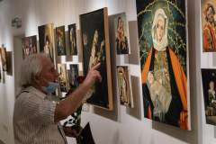 Kazimierz Białkowski palcem wskazującym prawej ręki pokazuje obraz Madonny.
