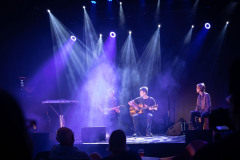 Zespół na scenie w świetle reflektorów. Zdjęcie utrzymane w niebieskiej tonacji.