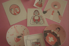 Na rózowej macie leżą kartki z obrazkami związanymi z Akcją Menstruacją.