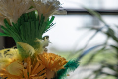 Palma z kwiatów z zielonej. białej i pomarańczowej bibuły.