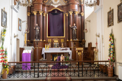 Ołtarz główny z zasłoniętym fioletową materią krzyżem.