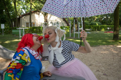 Paulina Pachulska-Wojdack z CKiS w Koninie z nosem klauna, parasolką, kitkami, pasiastej koszulce i różówej tiulowej spódnicze cmoka klauna.