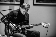 Artur Maćkowiak gra na gitarze elektrycznej.