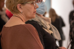 Kobieta w brązowym sweterku i okularach sfotografowana z prawego profilu.