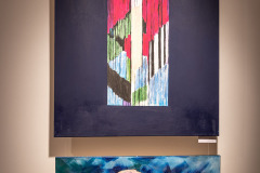 Zdjęcie dwóch prac wyeksponowanych na ścianie. Obraz wyżej to barwna kompozycja, poniżej przedstawia kwiat na niebieskim tle.