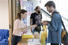 Biuro organizacyjne. Uczestnik OKFA odbiera materiały festiwalowe.
