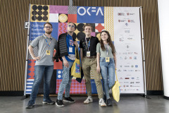 Na ściance OKFA pozuje czterech uczestników konkursu.