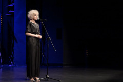 Paulina Pachulska-Wojdak w czerni przy mikrofonie na scenie CKiS-DK Oskard.