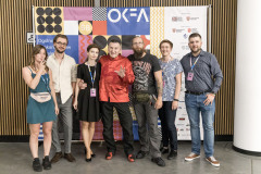 Pamiątkowe zdjęcie na ściance OKFA: nagrodzeni, organizatorzy, a w środku aktor i jeden z jurorów Krzysztof Majchrzak.