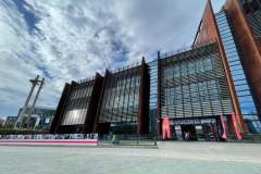 Europejskie Centrum Solidarności w Gdańsku - budynek z cegły i szkła. Z lewej Trzy Krzyże - pomnik upamiętniający Ofiary Grudnia 70.