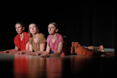 Fragment spektaklu. Trzy kobiety leżą na scenie na brzuchach. Podpierają się na przedramionach.