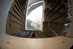 Zdjęcie zrobione z góry przez poręcz schodów. Widać poszczególne kondygnacje.