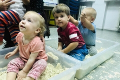 Zbliżenie na troje dzieci siedzących w pudełkach z piaskiem.