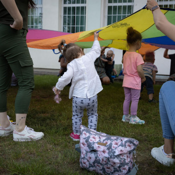 Dzieci podczas zabawy tęczową chustą.