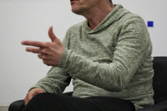 Zdjęcie portretowe. Robert Brzęcki mówi i gestykuluje lewą dłonią.