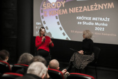 Przed ekranem siedzą Karolina Porcari z mikrofonem i Paulina Pachulska-Wojdak. Na pierwszym planie głowy publiczności i oparcia foteli. W tle slajd z napisem Środy z kinem niezależnym.
