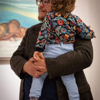 Ksawery Wójciński trzyma na rękach dziecko.
