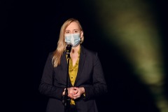 Joanna Szydłowska przemawia przez mikrofon ubrana w maseczkę.