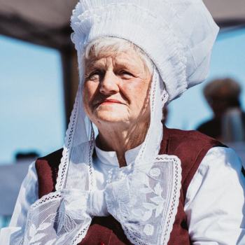 Zdjęcie portretowe. Starsza kobieta w białym czapcu z zawiązaną pod brodą kokardą.