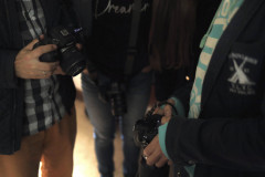 Brzuchy i część nóg czterech osób trzymających aparaty.