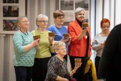 Grupa uczestniczek warsztatów pozuje do zdjęcia. W dłoniach trzymają wiklinowe koszyczki.