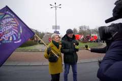 Justyna Kałużyńska-Markocka z fioletową flagą orkiestry. Obok niej mężczyzna z mikrofonem TVN.