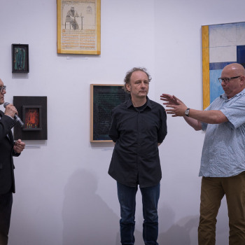 Po lewo Robert Brzęcki z mikrofonem, w środku Piotr Lutyński, po prawej Michał Kruszona z wyciągniętymi przed siebie rękami.