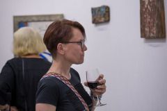 Katarzyna Szumigalska z CKiS w Koninie sfotografowana z prawego profilu w planie amerykańskim. Prawą rękę trzyma w kieszeni spodni, w lewej kieliszek wina.