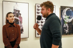 Dziewczyna w rdzawej bluzce. Włosy związane w kitkę. Za nią trzy plakaty zawieszone w rzędzie na ścianie. Po prawej Bartek Nowakowski z CKiS w Koninie z mikrofonem, sfotografowany z lewego profilu.