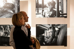 Mężczyzna i kobieta oglądają cztery czrano-białe fotografie.
